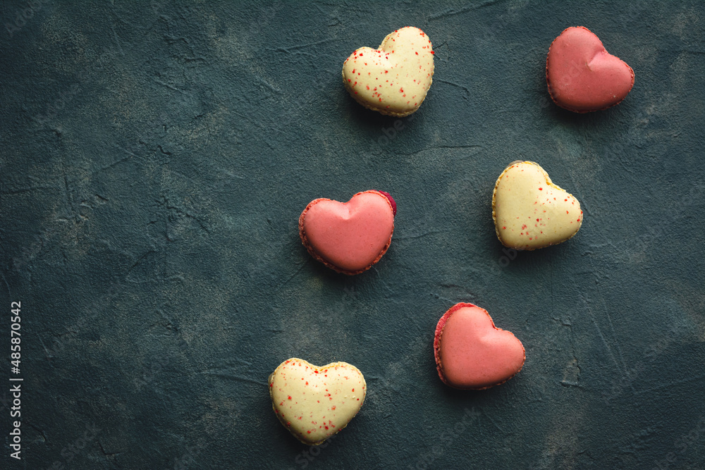 Obraz premium Macarons cakes in a shape of a heart. Small French cakes for Valentines Day. Sweet and colorful french macaroons.