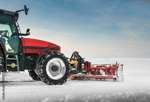 Tractor cleaning snow in field