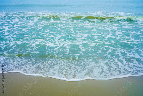 Fototapeta Naklejka Na Ścianę i Meble -  Dreamy beach.Cloudy blue sky over the ocean background.Marine beach landscape with front view of falling waves and sand in a foreground. Ocean beach vacation. Baltic sea, Kaliningrad region.