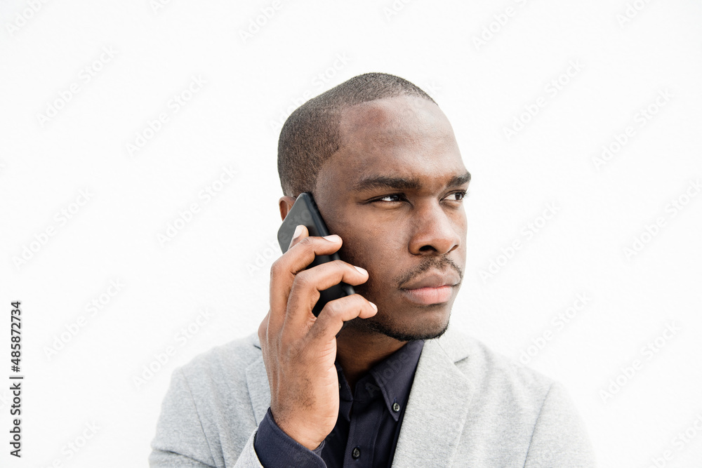 Close up African American business man talking with phone by isolated white background Close up African American business man talking with phone by isolated white background