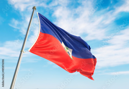 3d rendering Haiti flag waving in the wind on flagpole. Perspective wiev Haiti flag waving a blue cloudy sky