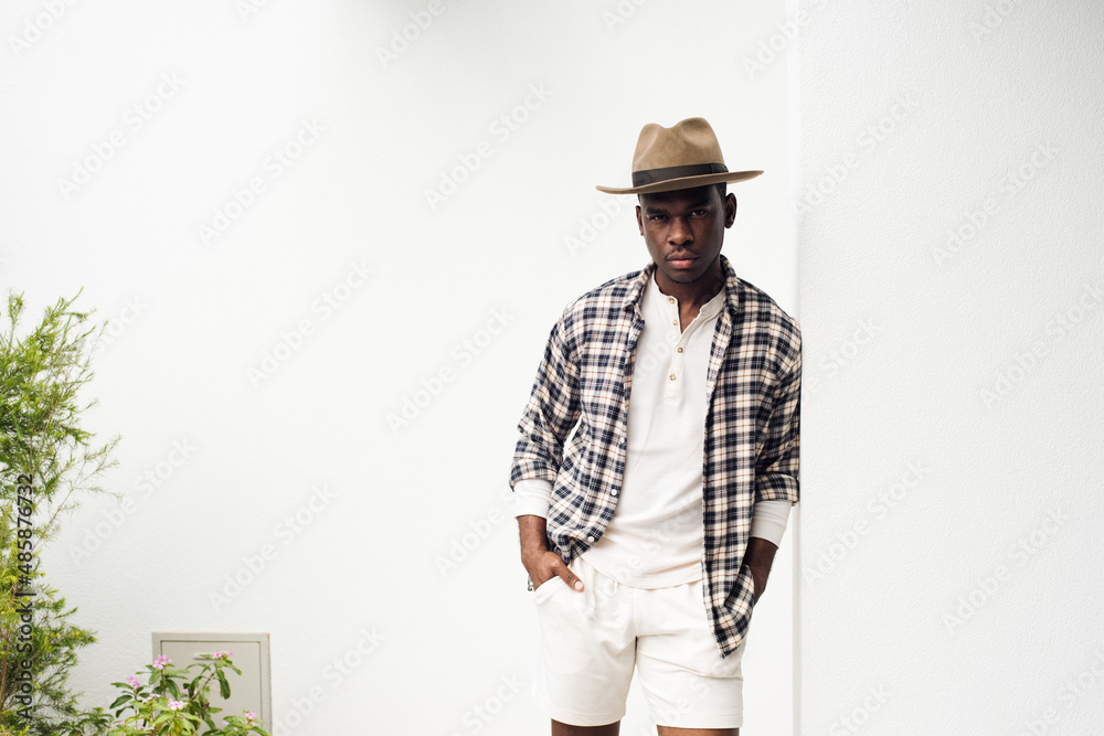 cool african american guy with hat leaning against wall cool african american guy with hat leaning against wall