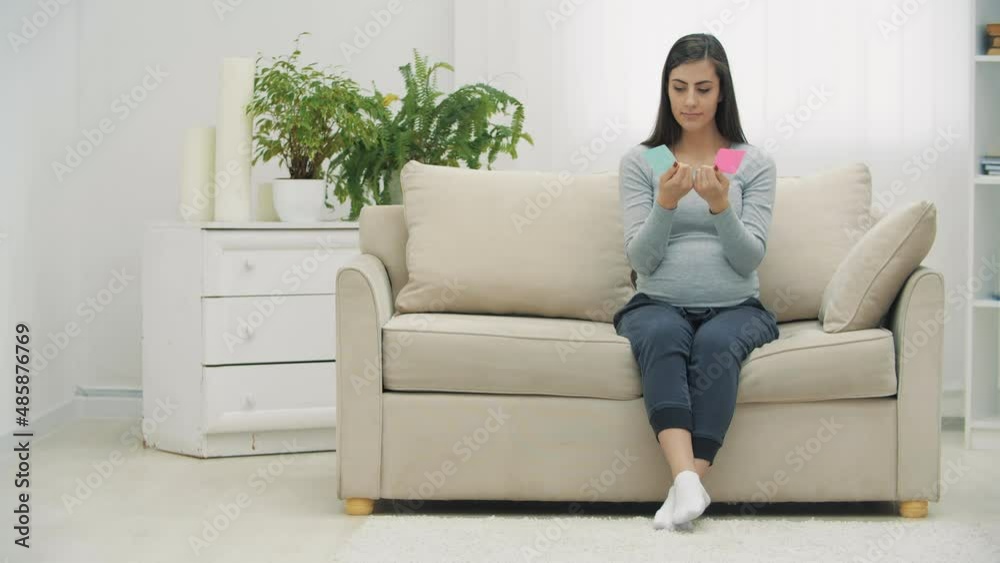 4k video of pregnant woman holding pink and blue papers which mean gender of future baby. 4k video of pregnant woman holding pink and blue papers which mean gender of future baby.