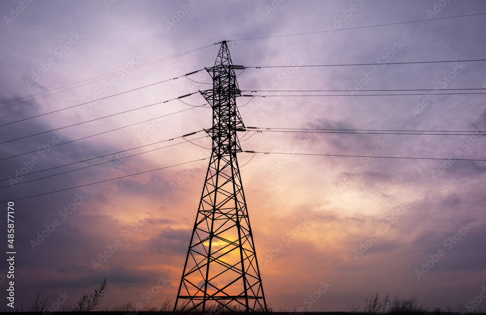 silhouette of power lines against the background of a cloudy sunset, saturated sky and pylons