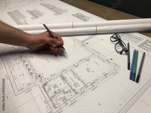 Architectural project design and sketching. Sketch pencils, glasses and male designer hand on map.