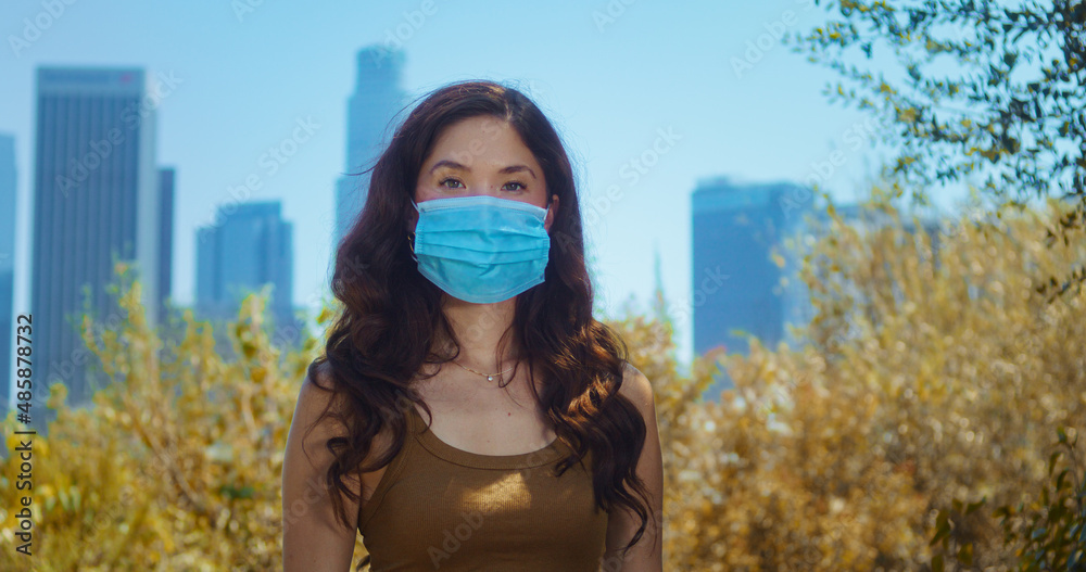 Woman wearing medical mask outdoor closeup. Asian girl cover face against covid