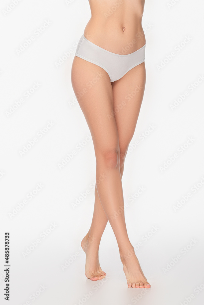 cropped view of barefoot and slim woman standing on white background