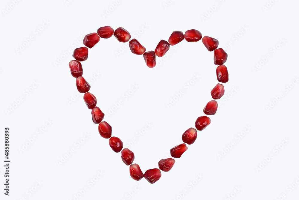 Heart made of pomegranate seeds, isolated on white background, copy space for text Heart made of pomegranate seeds, isolated on white background, copy space for text