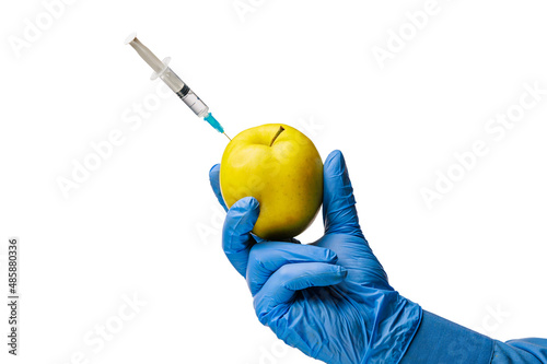 Hand or palm of a doctor in classic medical gloves holds an apple with a syringe. White isolated background