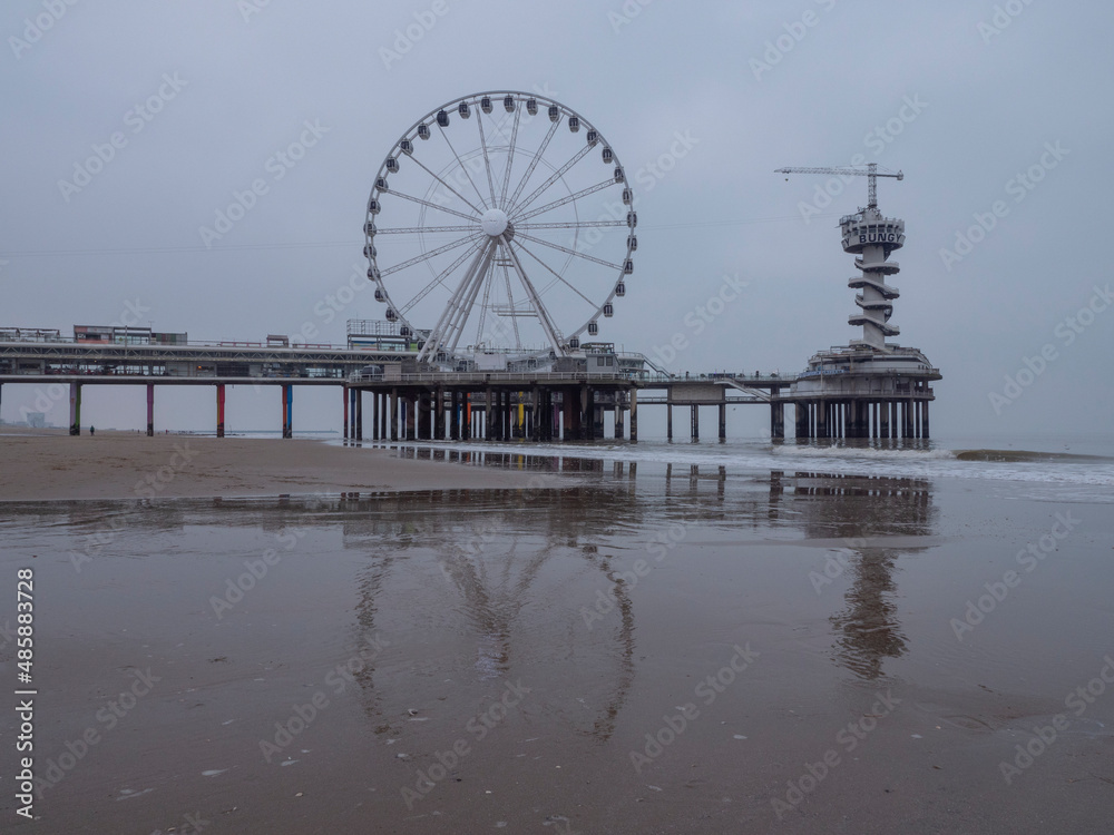 Dutch city Scheveningen pier on the beach with ferris wheel and bungee jump tower, Aerial