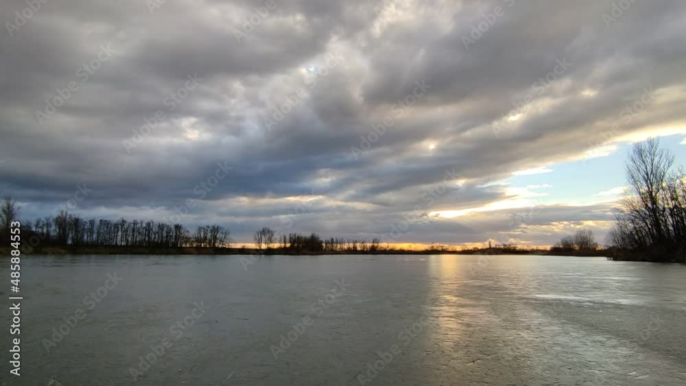 Afternoon clouds above the frozen lake. 4K time lapse.