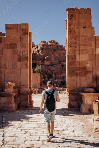 Tourist with a backpack visiting the sights of the ancient fabulous city of Petra in Jordan. Colorful photos. Vacation, vacation and travel concept
