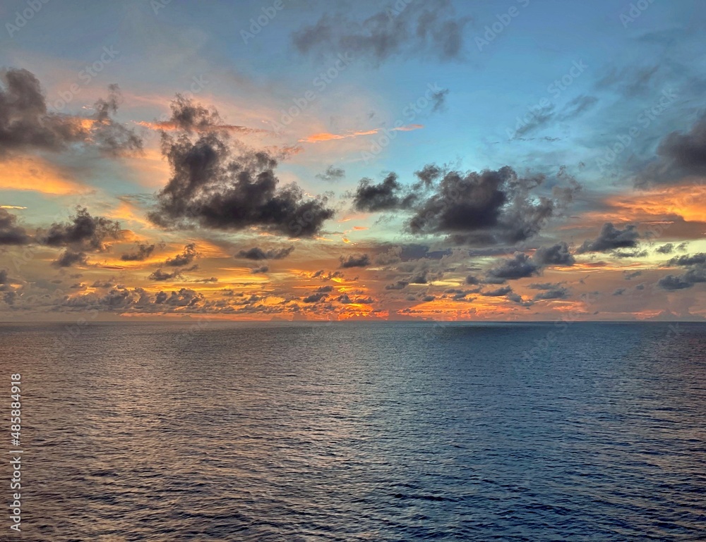 Sunset in the middle of the Atlantic Ocean whilst being at a distance of 90 Nautical miles from storm, sea showing ripples from the horizon to the clouds, 