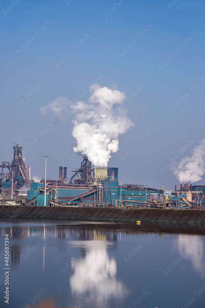 03 April 2016 Amsterdam, IJmuiden, Netherlands, Panoramic Image of the Tata Steelworks with smoke billowing out from multiple chimneys in a sunny day