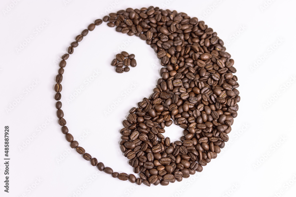 yin yang sign made by coffee beans on white background yin yang sign made by coffee beans on white background