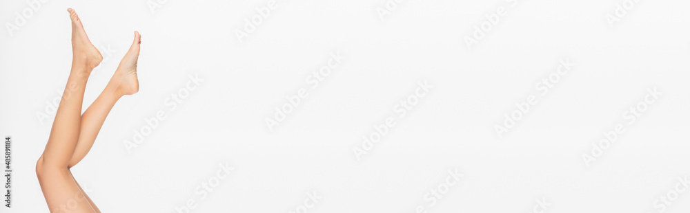 cropped view of slim barefoot legs of young woman isolated on white, banner cropped view of slim barefoot legs of young woman isolated on white, banner
