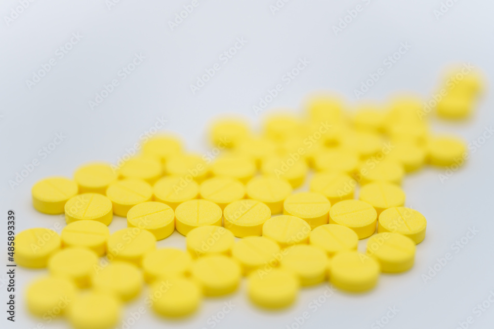 Medical and Healthcare Concept. Closeup of pile of yellow pills on white background. Medical and Healthcare Concept. Closeup of pile of yellow pills on white background.