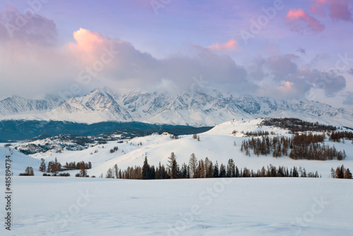 Mountain winter landscape at dawn. Clouds in the morning light. A lot of snow. Beauty of nature. Russia, Altai.
