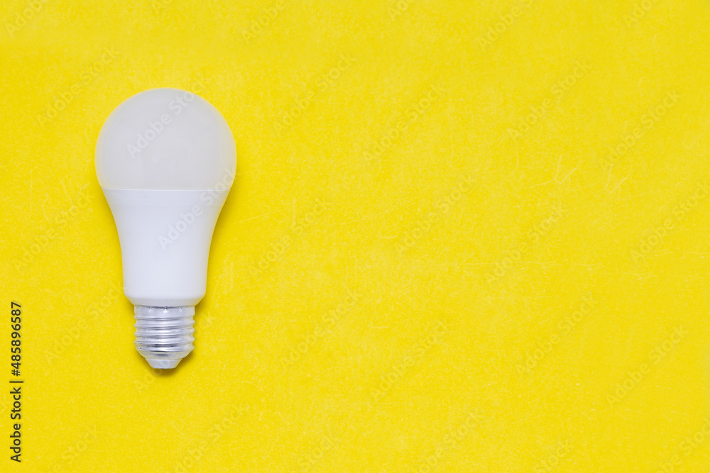 Electric light bulb on a yellow background. Space for text. Copy space. Electric light bulb on a yellow background. Space for text. Copy space.
