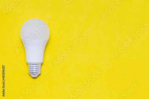 Electric light bulb on a yellow background. Space for text. Copy space.