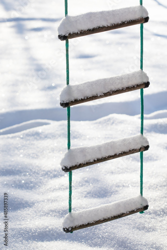 Children s rope ladder covered with snow after snowfall
