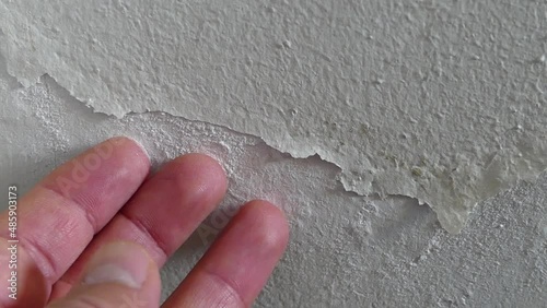 The paint on the wall of a damp house is peeling and blistering, damp wall, moldy house wall,