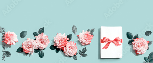 Gift box with pink roses overhead view - flat lay