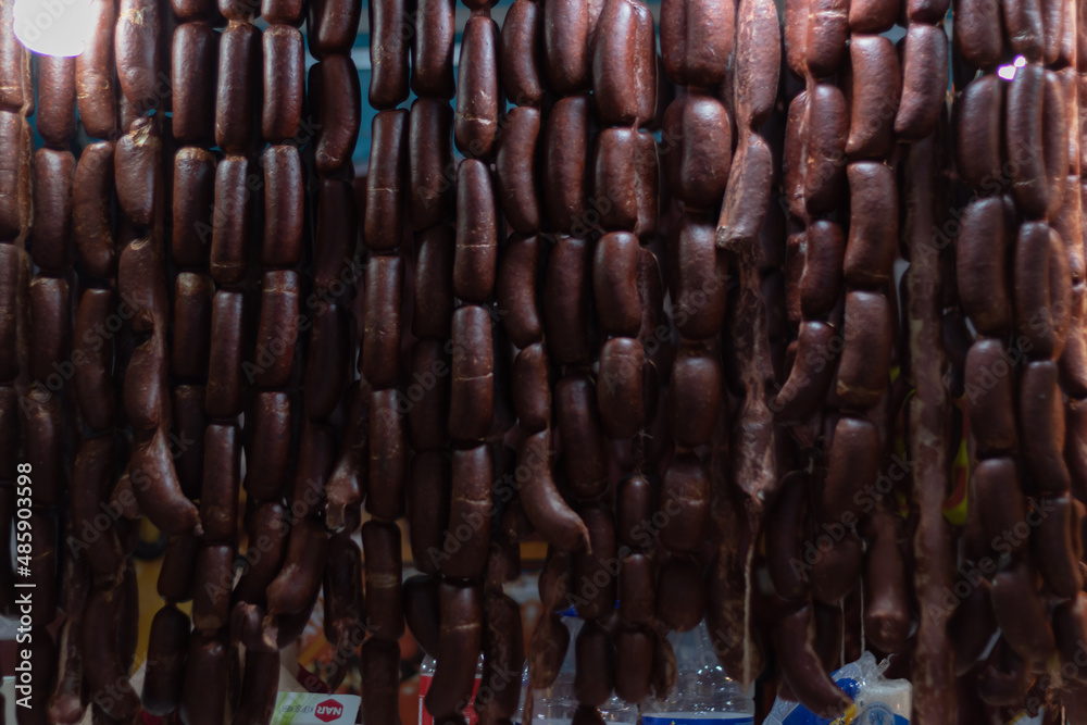 Sausage hanging and curing. Traditional food. Smoked sausages meat hanging in domestic smokehouse.
