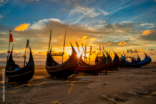 View of traditional fishing boats along the shoreline at sunset on the beach on St. Martin's Island, Teknaf, Chittagong, Bangladesh. photo