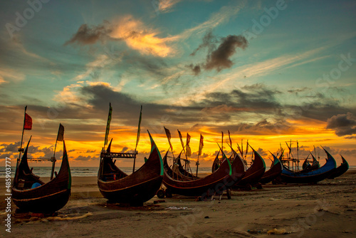 View of traditional fishing boats along the shoreline at sunset on the beach on St. Martin's Island, Teknaf, Chittagong, Bangladesh. photo