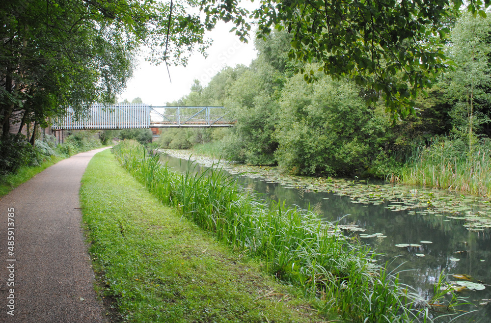 View of Empty Towpath beside Reflecting Waters of Industrial Canal