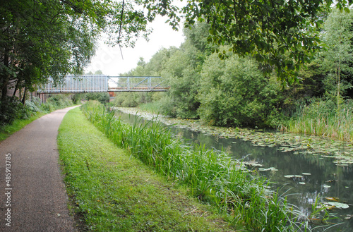 View of Empty Towpath beside Reflecting Waters of Industrial Canal