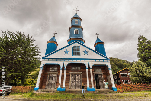 Holzkirche Nuestra Senora Del Patrocinio in Tenaun auf Chiloe mit weißer Fassade, blauen Sternen und Kirchtürmen sowie weißen Säulen im Eingangsbereich photo
