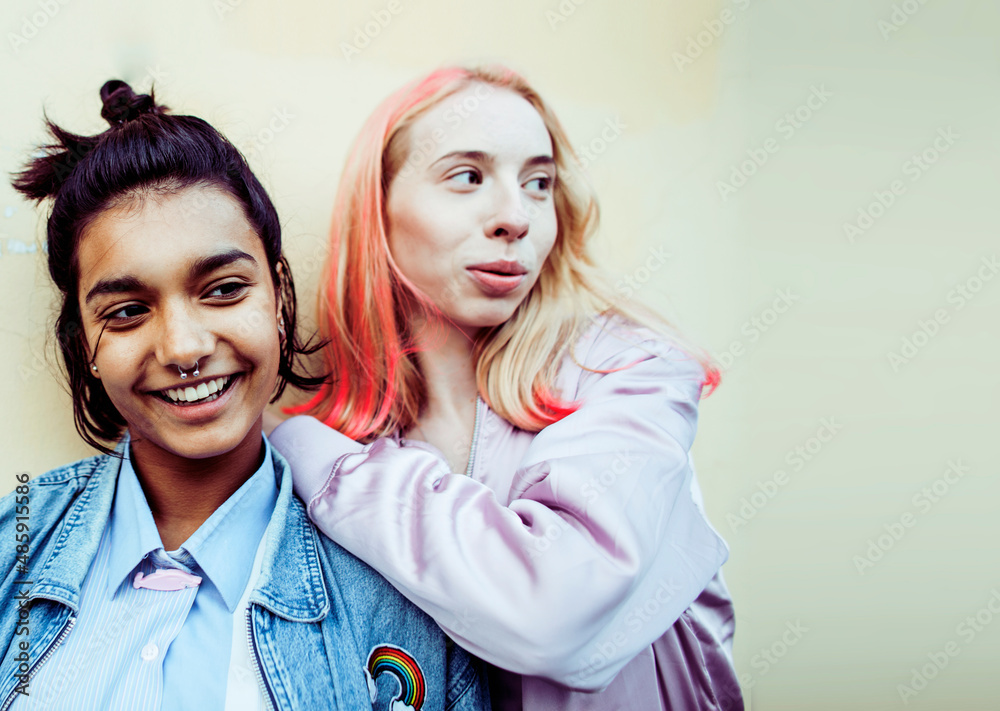 Two teenage girls infront of university building smiling, having fun, lifestyle real people concept Two teenage girls infront of university building smiling, having fun, lifestyle real people concept