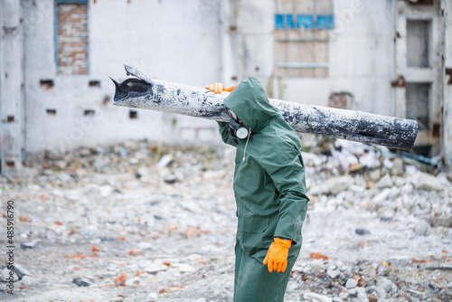 A man in a protective mask and protective clothing explores the danger zone. Ecological catastrophe. selective focus