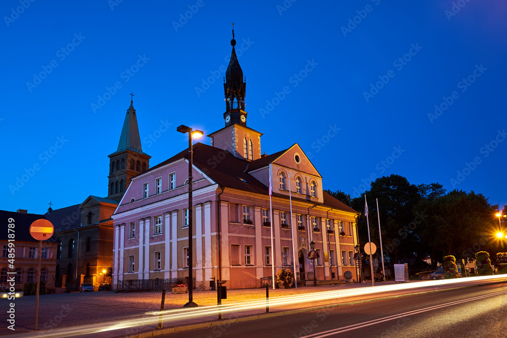The market square with the town hall and the church bell tower in the town of Miedzyrzecz at night