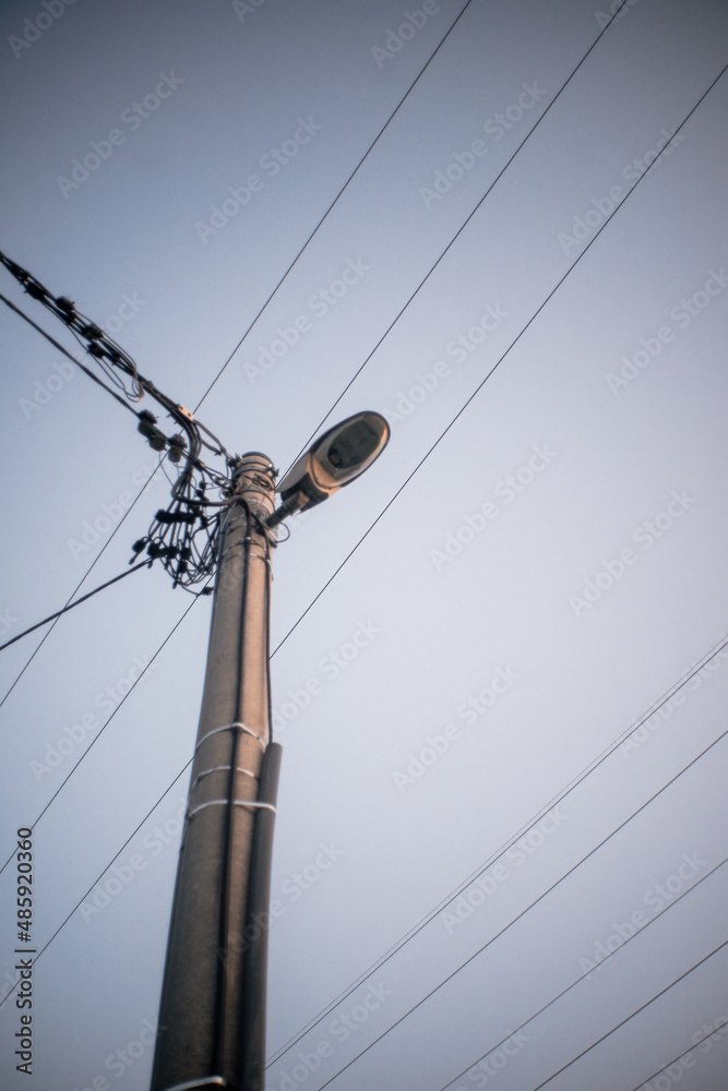 The street electric pole with a lamp and lot of wires - obrazy, fototapety, plakaty 