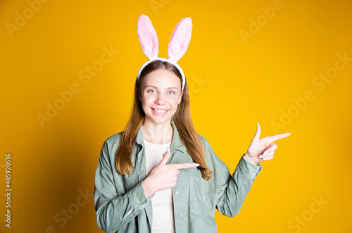 Wallpaper Mural blonde girl stands on a yellow background and shows that everything is fine in the rabbit's ears Torontodigital.ca