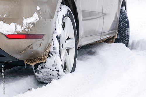 Car tires on winter road covered with snow