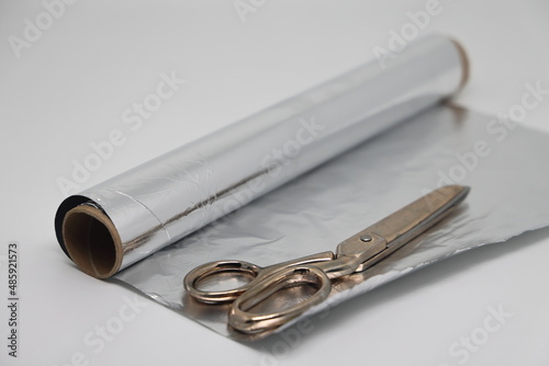 Metal food foil cut into strips and scissors. For sharpening scissors in everyday life.