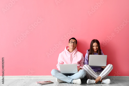 Young couple using laptops ...
