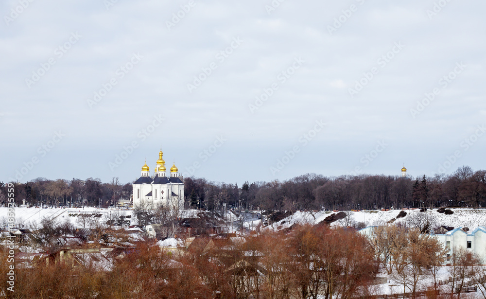 Orthodox Church of St. Catherine in the Ukrainian city of Chernihiv and a view of the city in winter with snow. Old beautiful temple in the city.