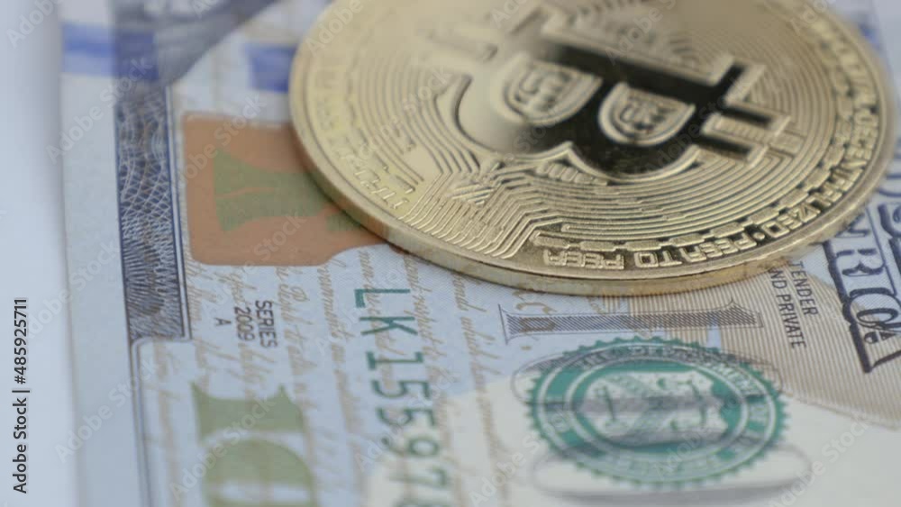 Bitcoin BTC coin and 100 dollar bill rotating, close-up shot. Digital money path