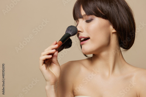 brunette makeup brushes in hand model makeup posing close-up Lifestyle