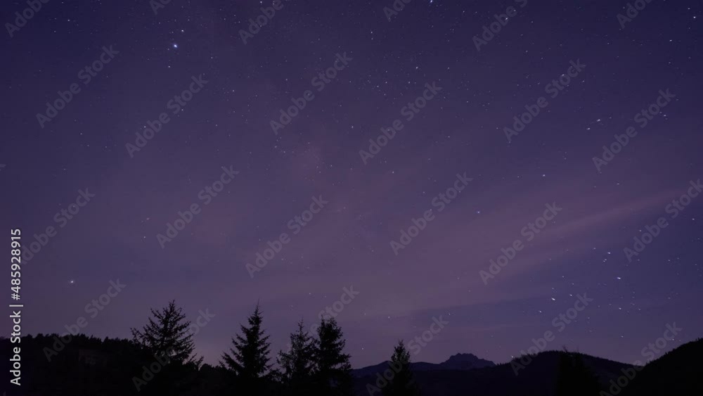 Starry sky with milky way, colorful clouds, silhouette of forest landscape Starry sky with milky way, colorful clouds, silhouette of forest landscape