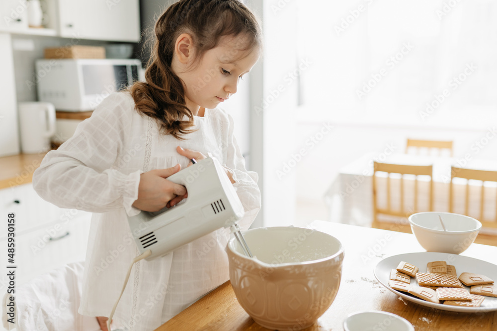 Adorable girl preparing icing pancakes at the kitchen. Concept of food preparation. Casual lifestyle photo series in real life interior Adorable girl preparing icing pancakes at the kitchen. Concept of food preparation. Casual lifestyle photo series in real life interior