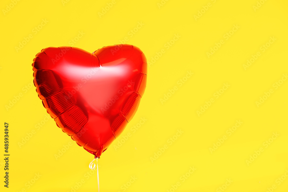 Beautiful heart-shaped balloon for Valentine's Day celebration on yellow background Beautiful heart-shaped balloon for Valentine's Day celebration on yellow background