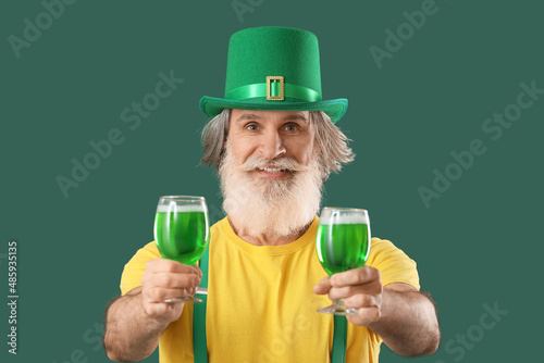 Senior man with beer on gre...