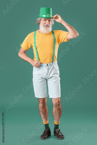 Senior man in hat on green ...