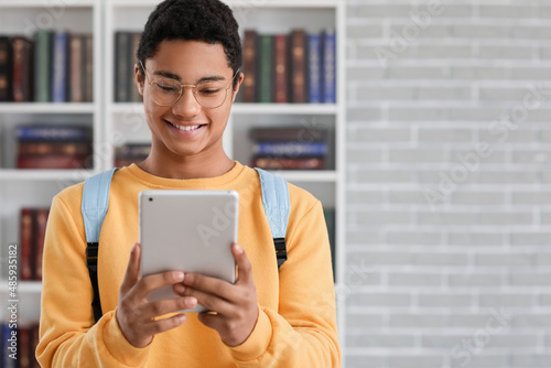 Male African-American student with tablet computer in library